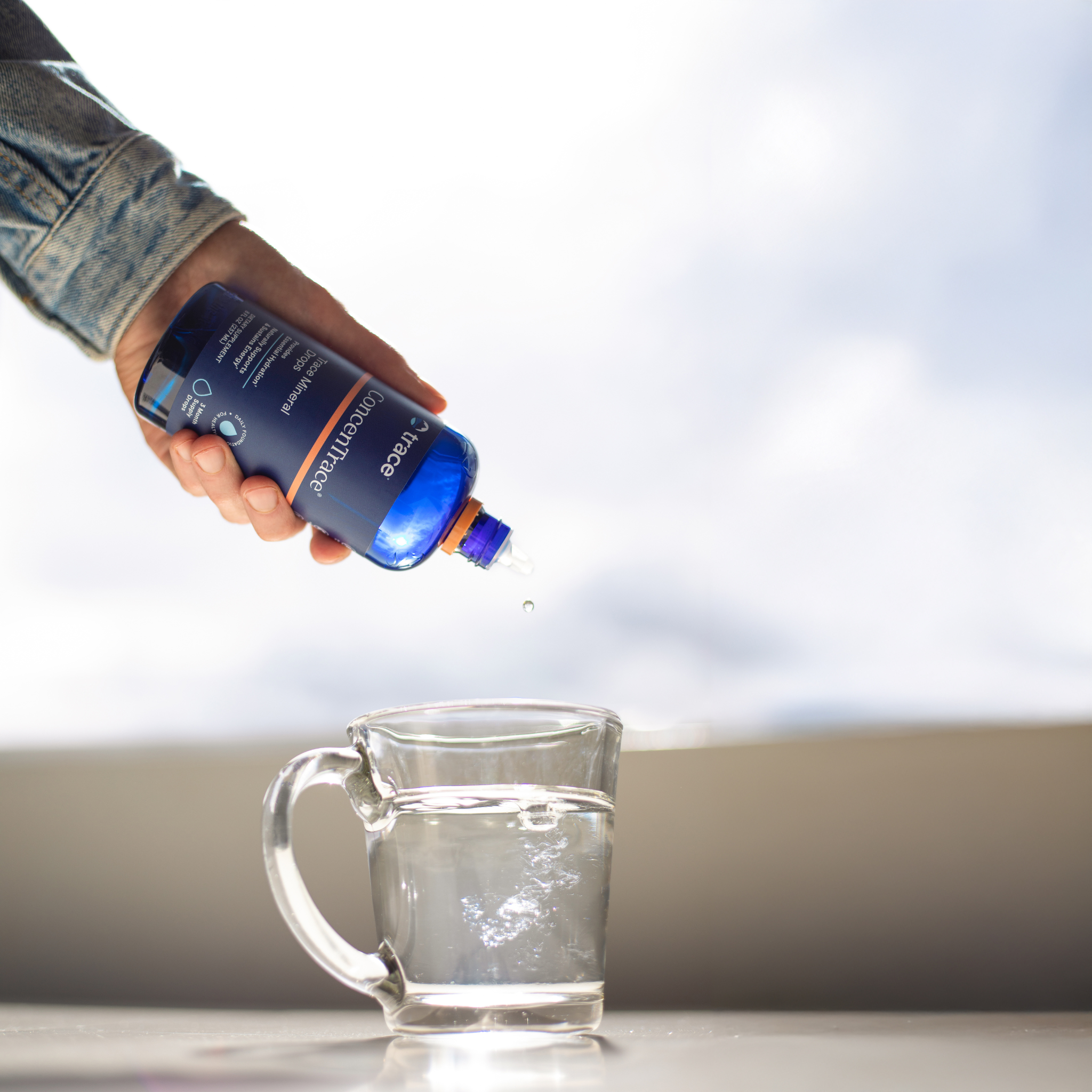 Trace minerals Concentrace joninių mineralų pakuotė 237 ml paversta žemyn ir lašinama į vandens stiklinę